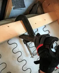 Hands measuring sagging seat cushion before all foam replacement service