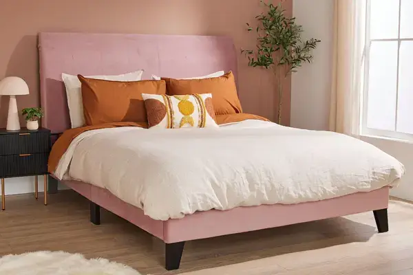 Elegant Bed with Pink Upholstery and Cushions in a Stylish Bedroom